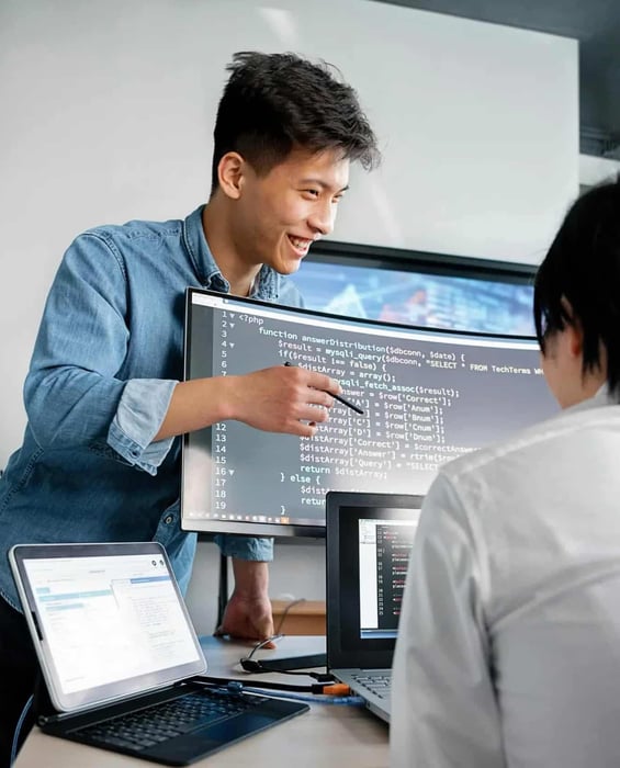 Developer presenting code to a colleague during a software development meeting